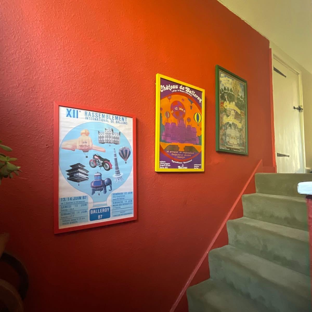 Three vintage French hot air balloon rally posters in colourful frames on staircase