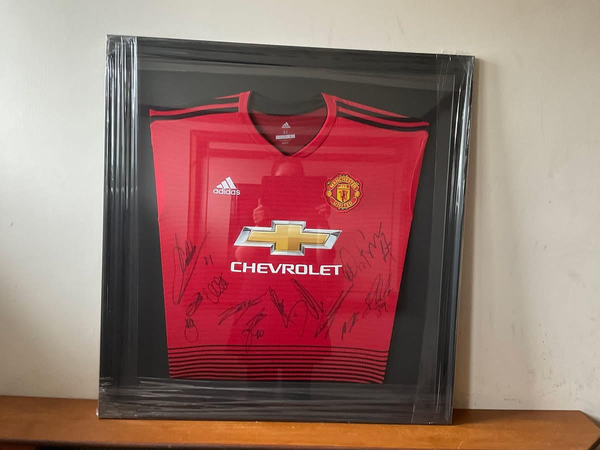 Signed Manchester United football shirt in black shadow box frame